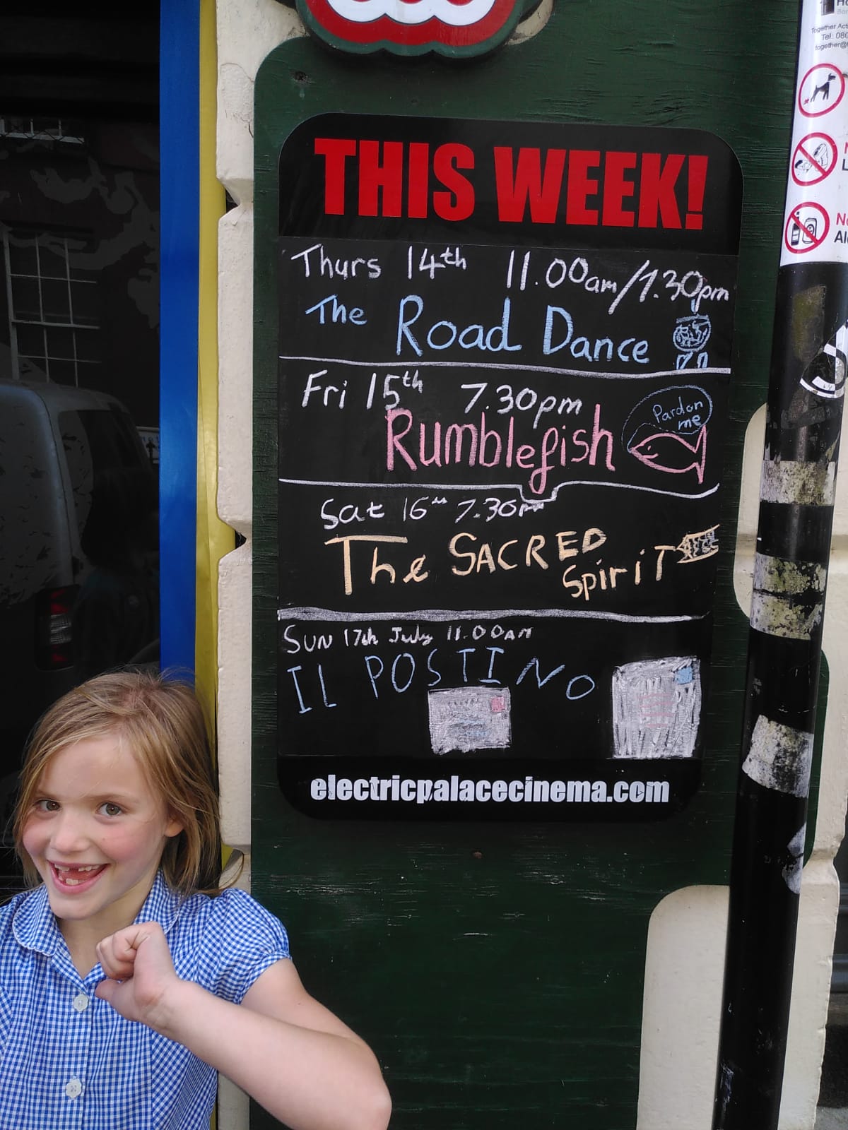 Girl smiling outside chalkboard